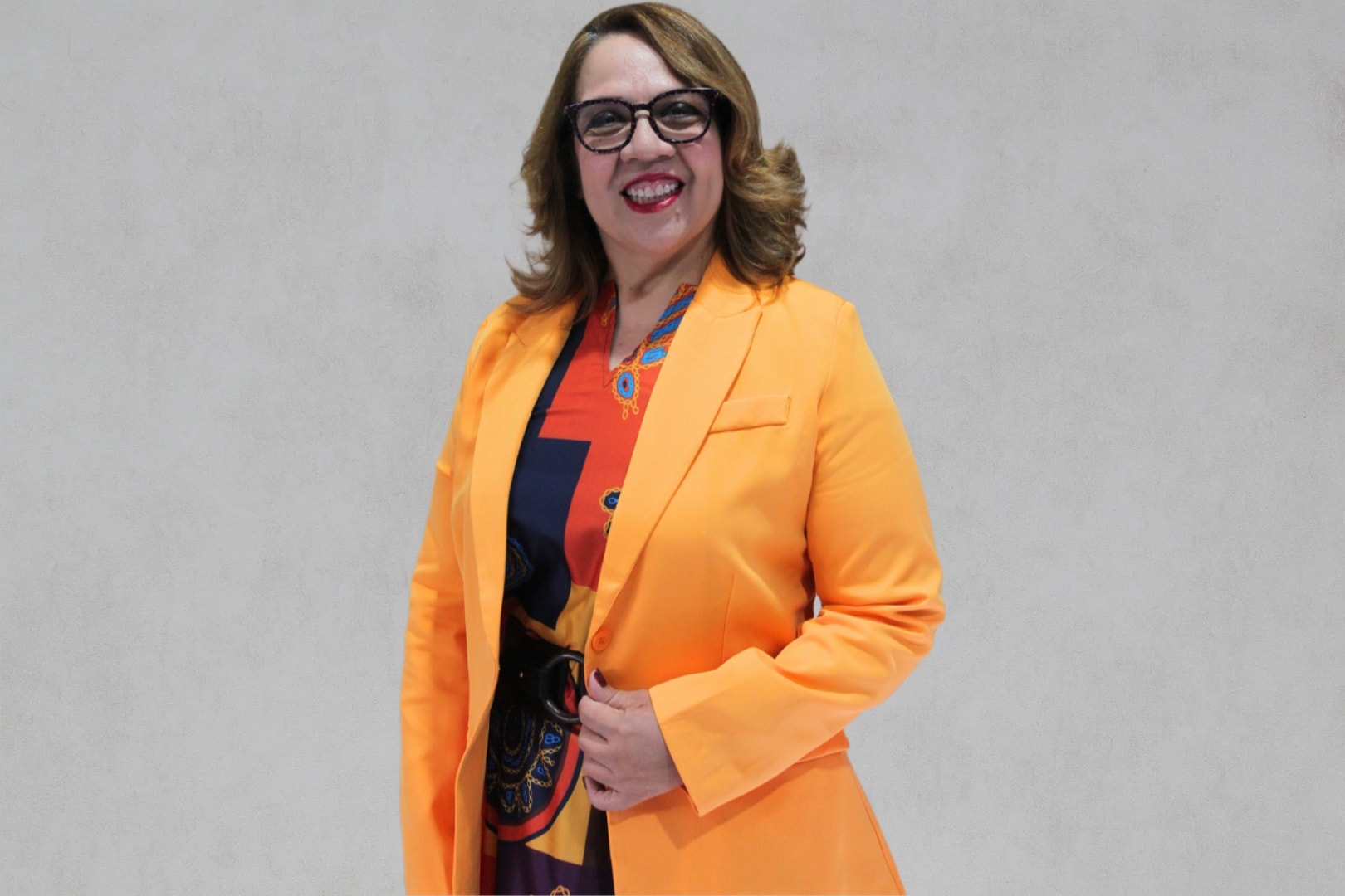 Dra. Jenny Lissette Castro de Hernández, oncóloga clínica, sonriendo profesionalmente con blazer naranja